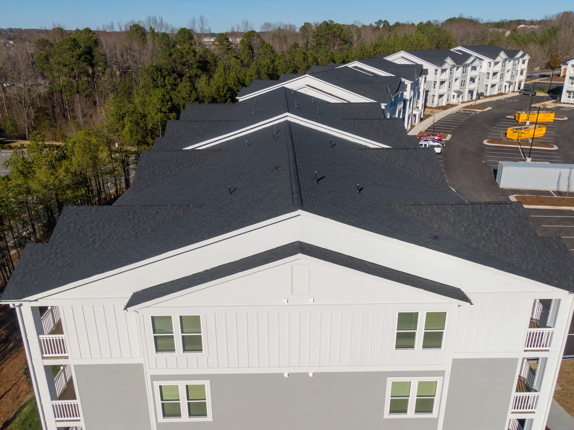 An aerial view of a large apartment building with a black roof.