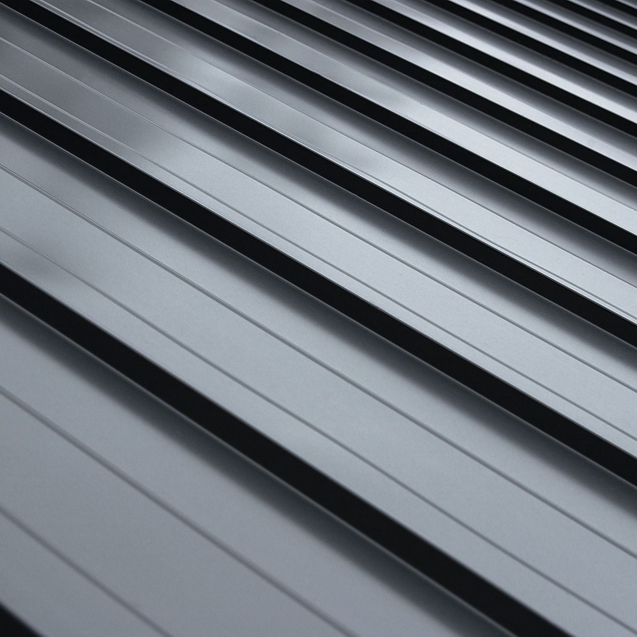 A close up of a black metal roof with a diagonal pattern