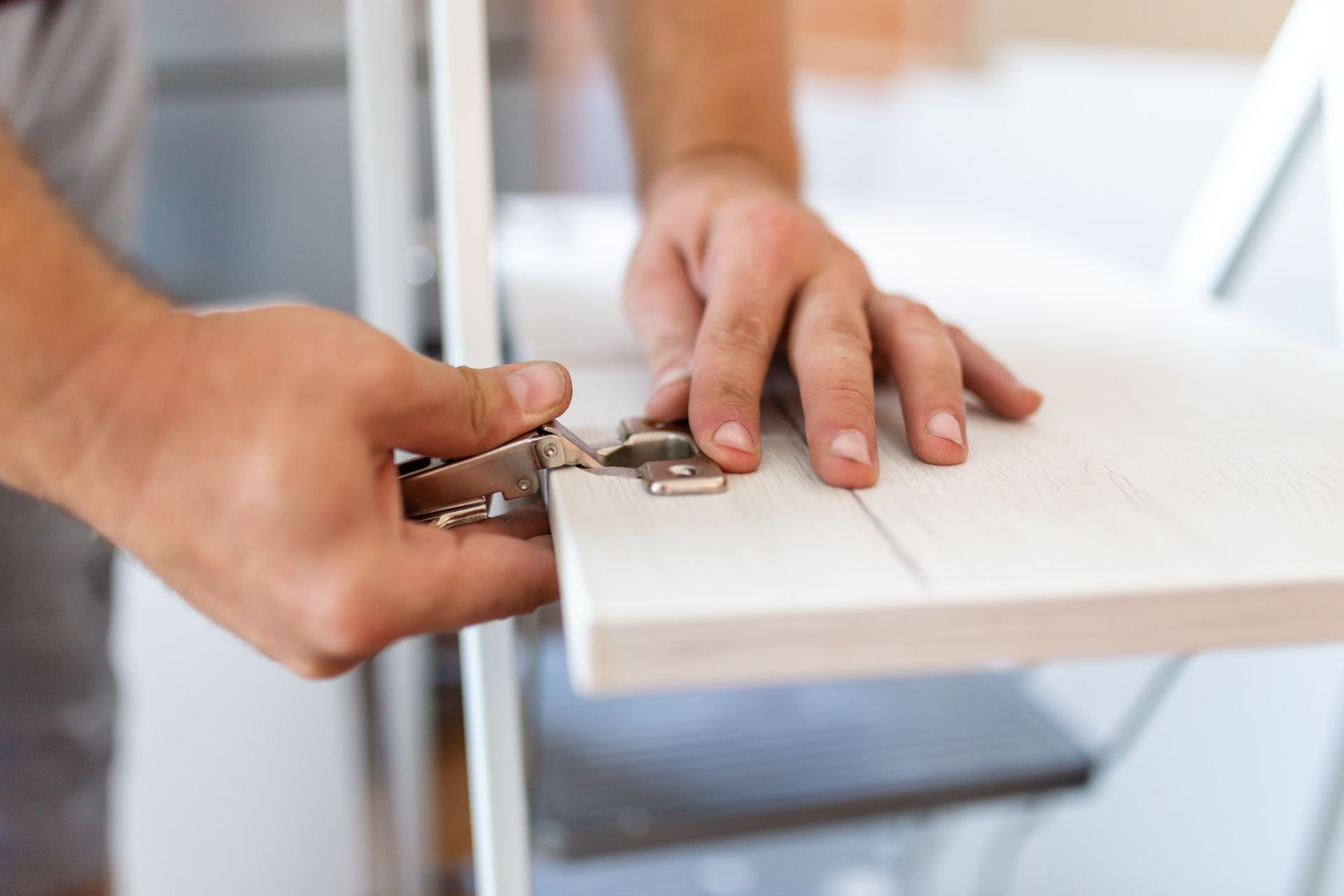 hands_attaching_hinge_to_furniture_door