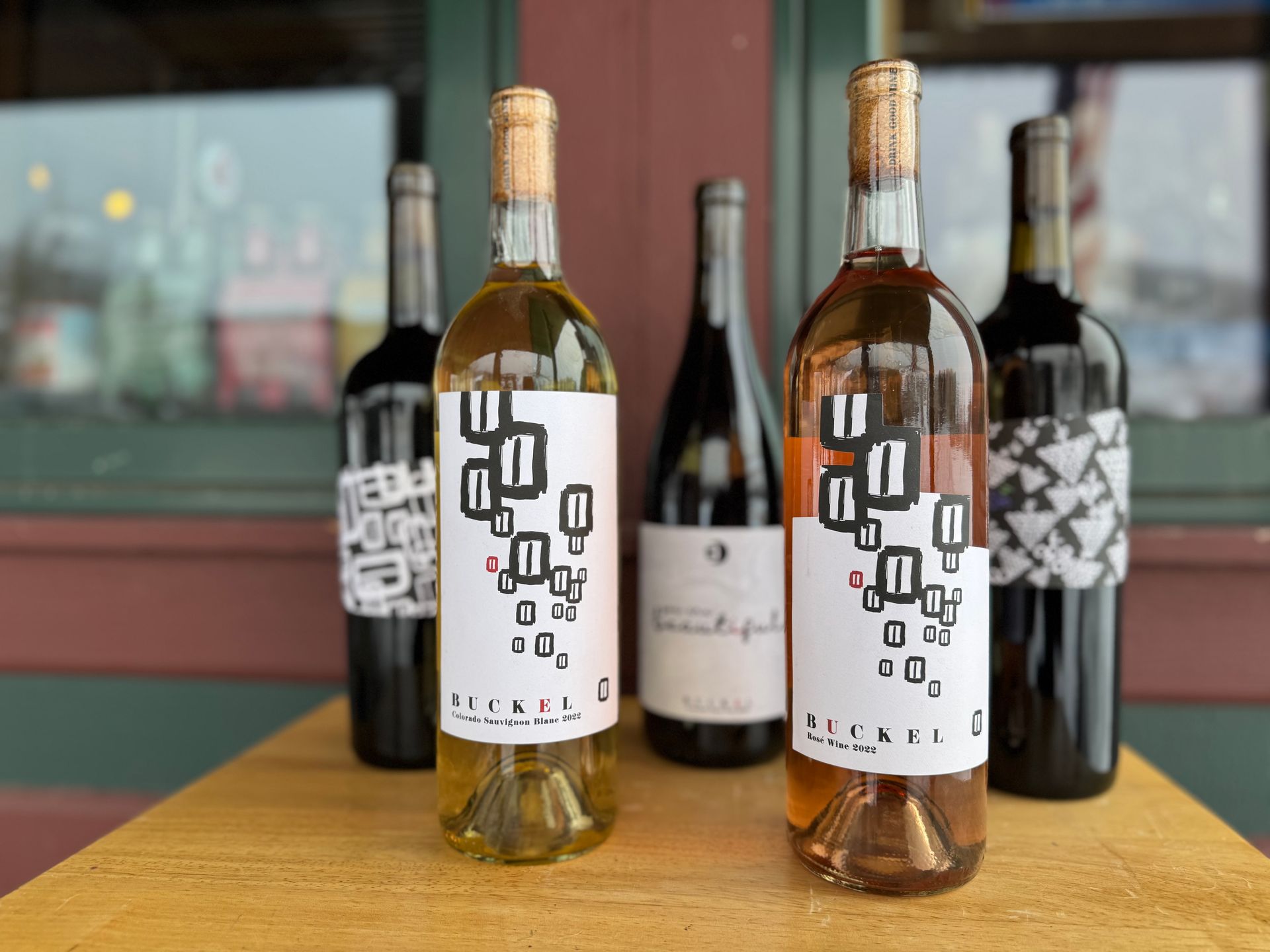 A group of wine bottles sitting on top of a wooden table.