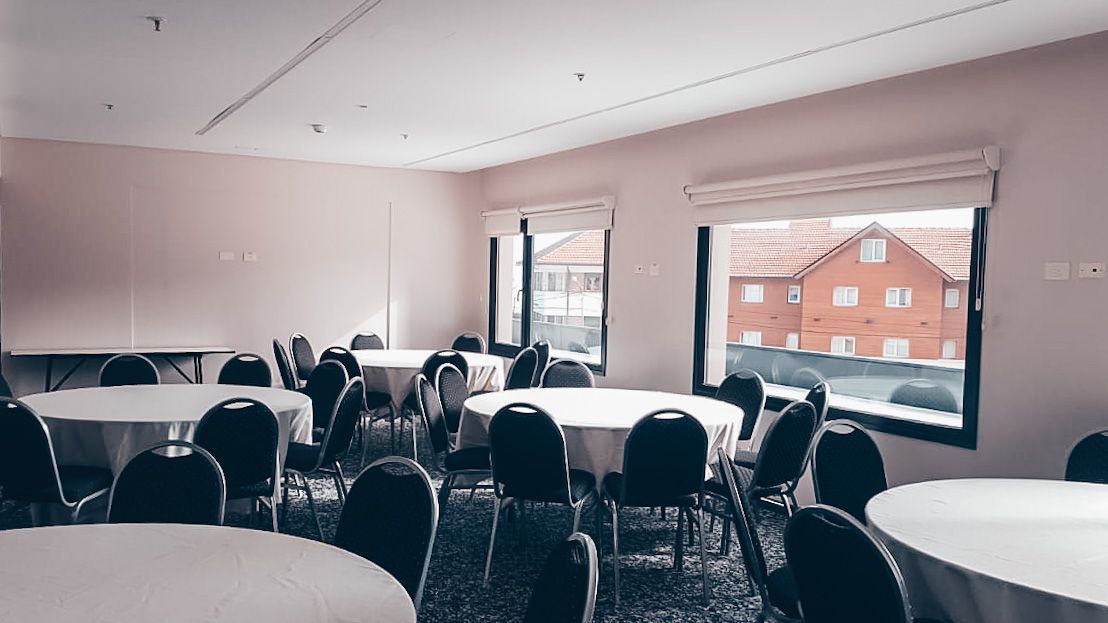 Una habitación llena de mesas y sillas y una ventana.