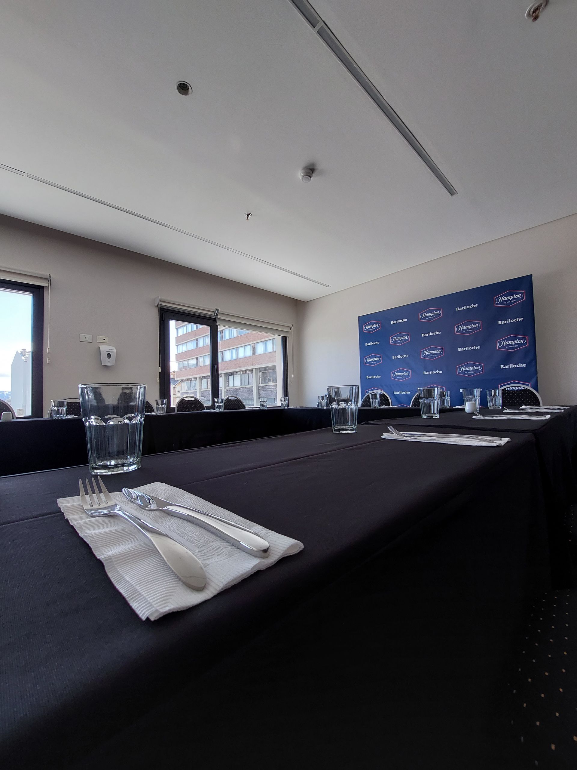 Una sala de conferencias con mesas preparadas para una reunión.