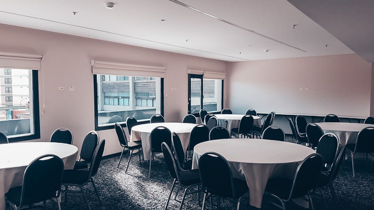 Hay muchas mesas y sillas en la habitación.