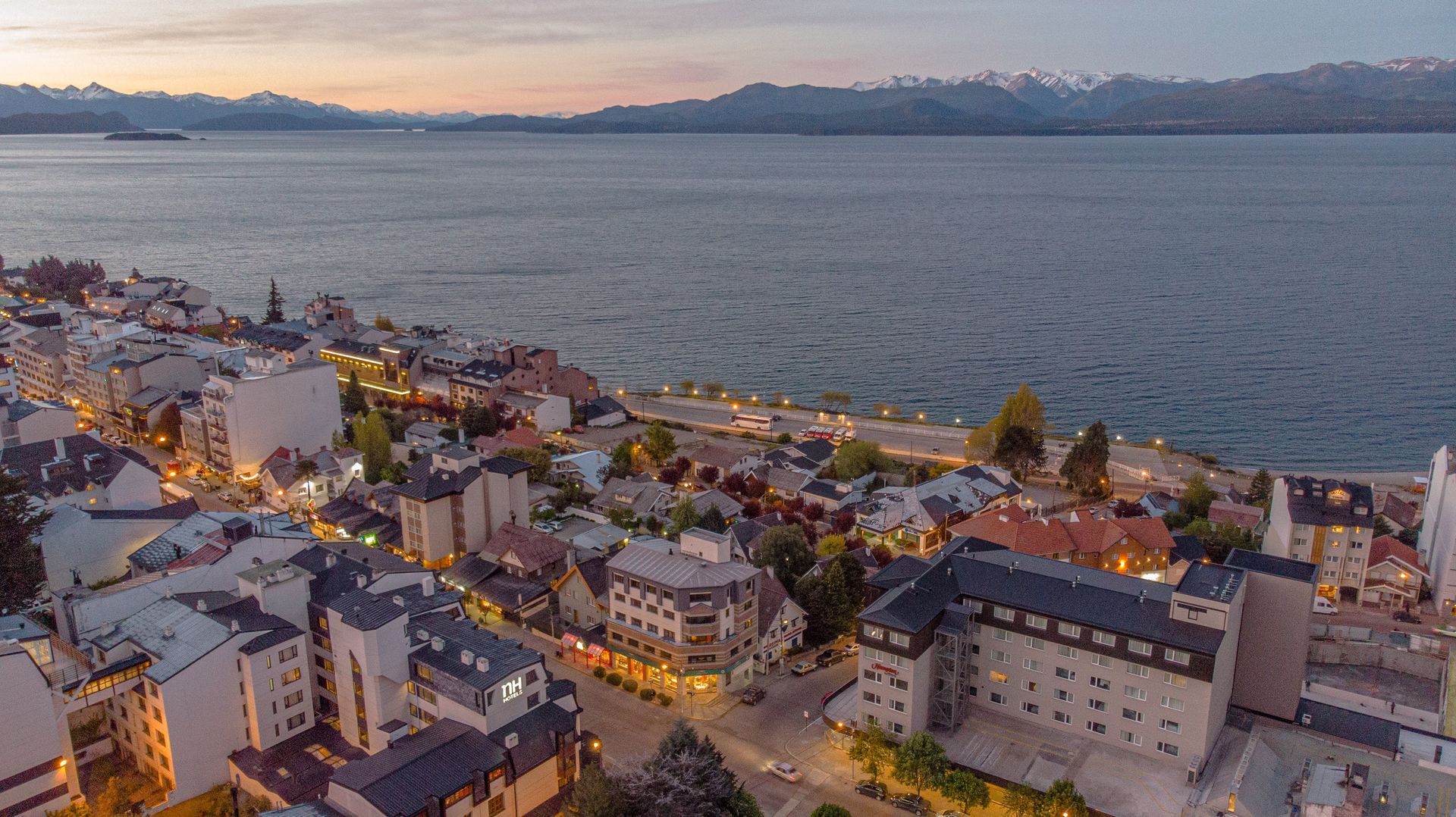 Una vista aérea de una ciudad junto a un cuerpo de agua por la noche.