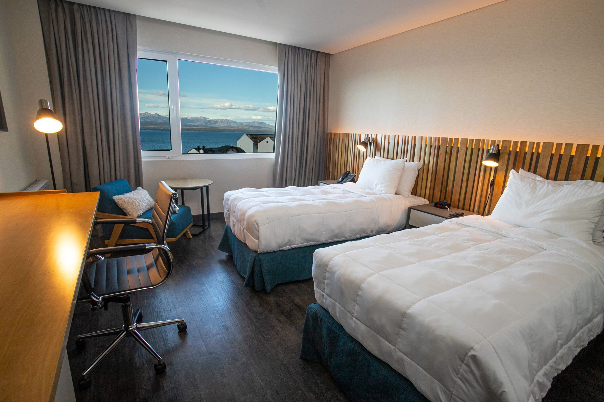 Un lago rodeado de árboles con montañas al fondo.