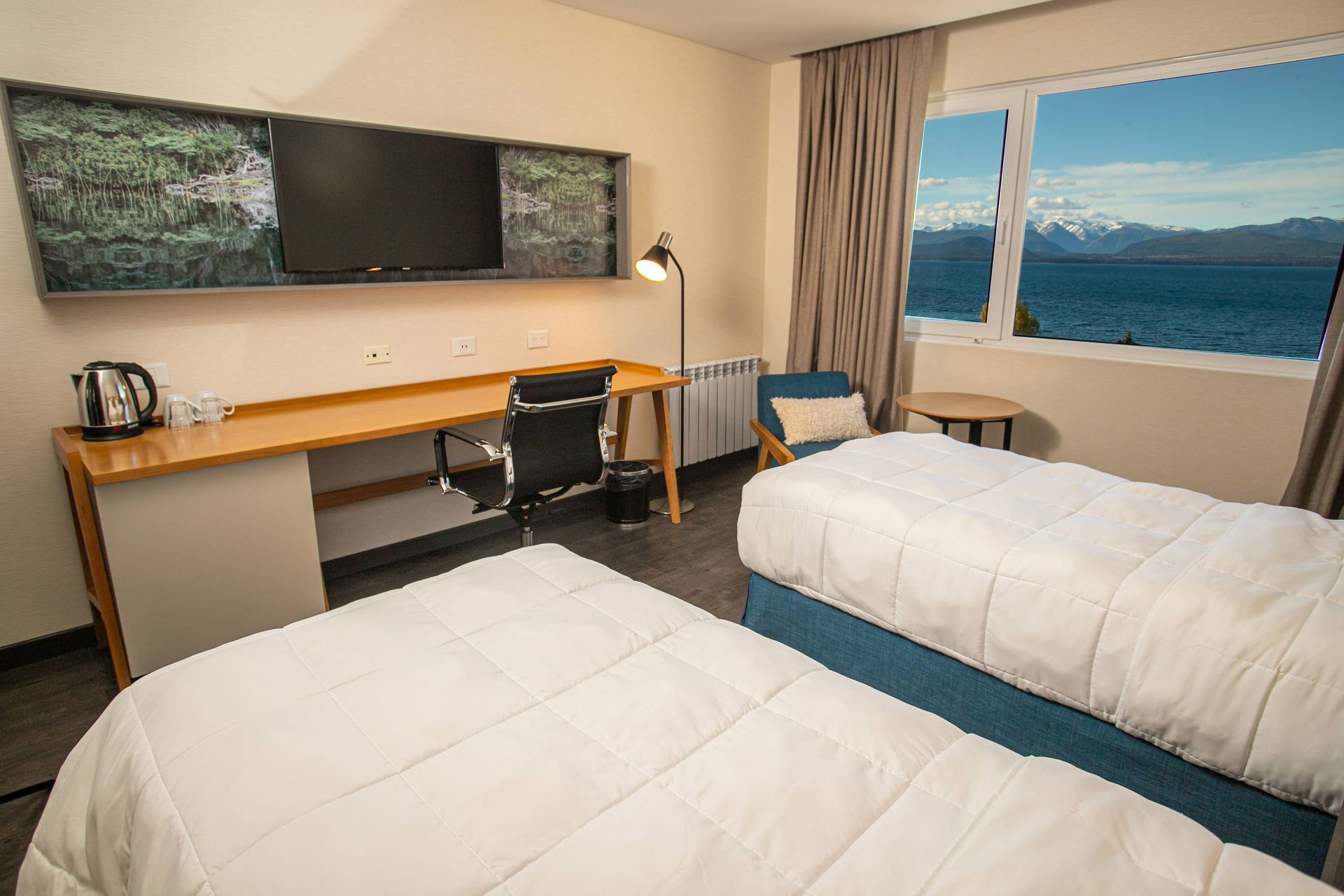Una habitación de hotel con dos camas, un escritorio y una televisión.
