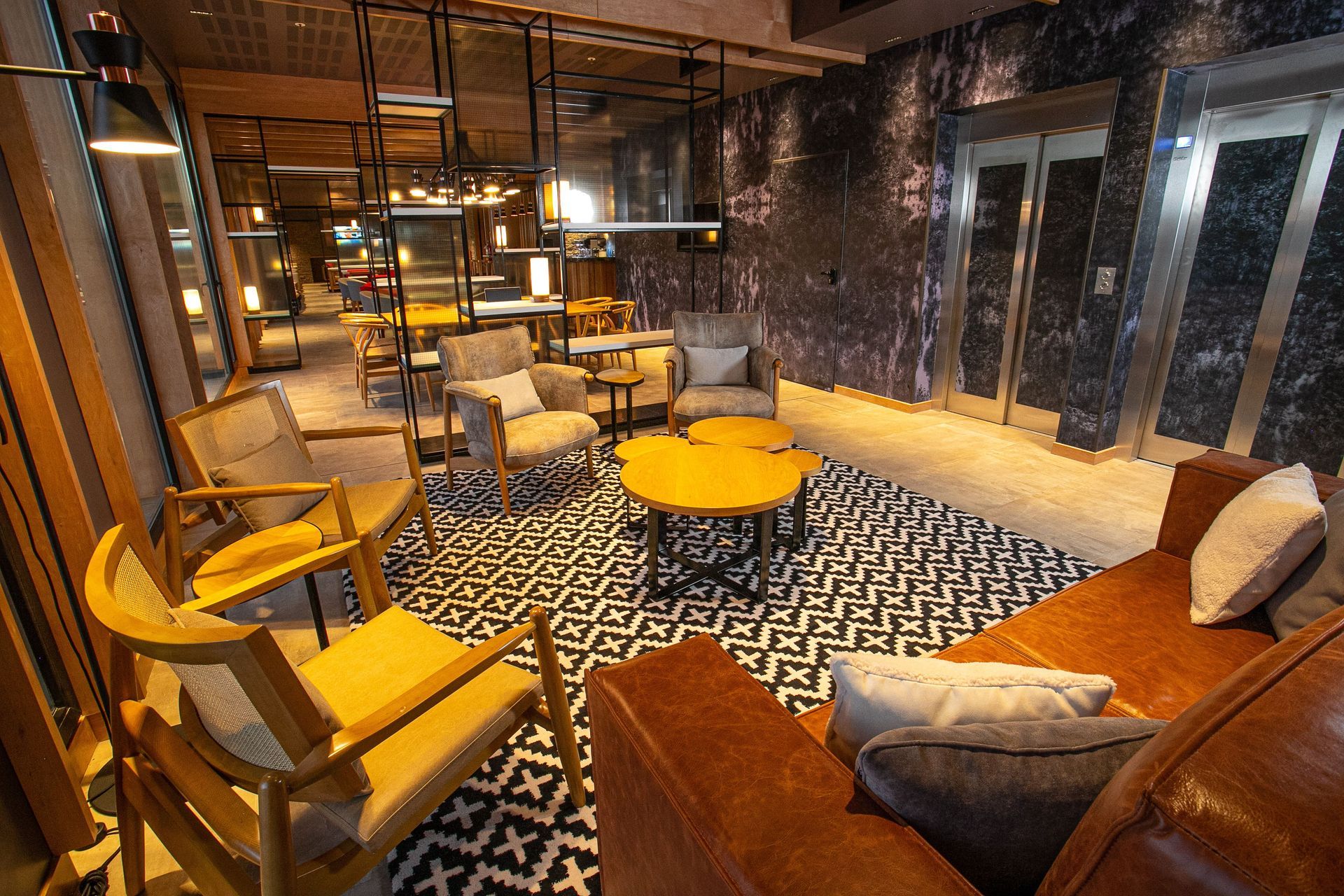 Una sala de estar con sofá, sillas y mesas.