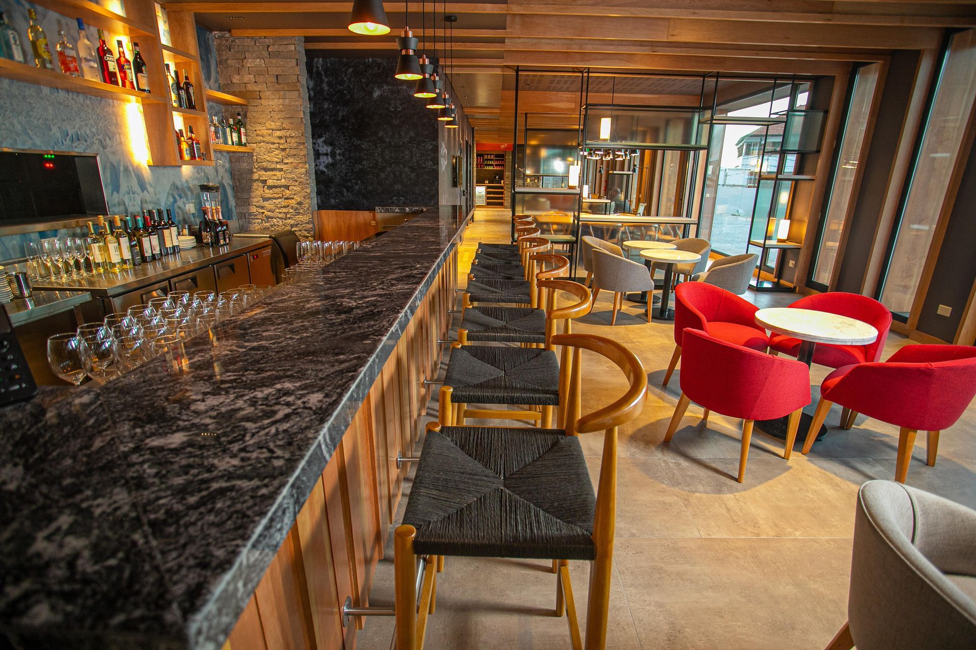 Un restaurante con una larga barra y mesas y sillas.