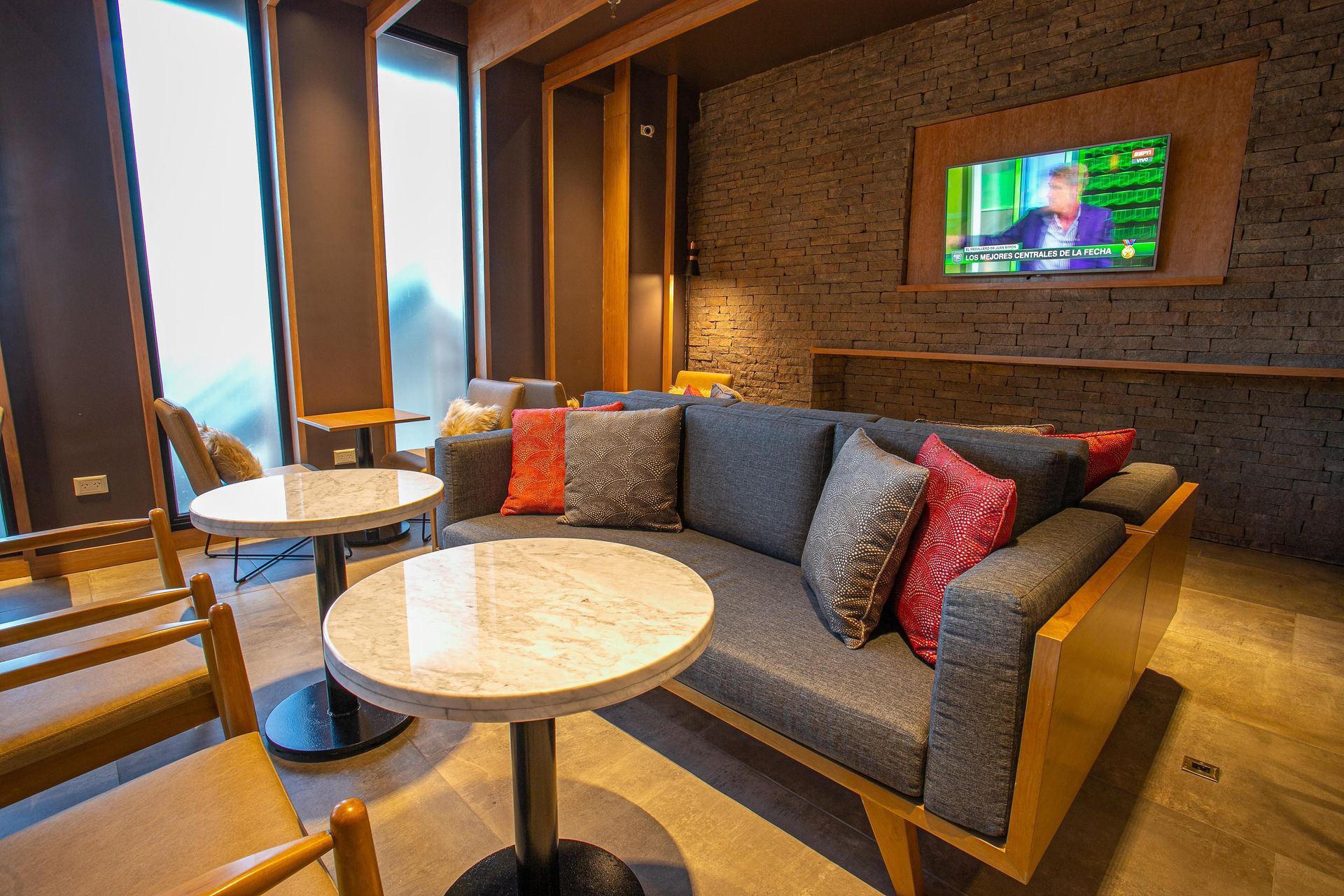 Un salón con sofá, mesa, sillas y televisión.