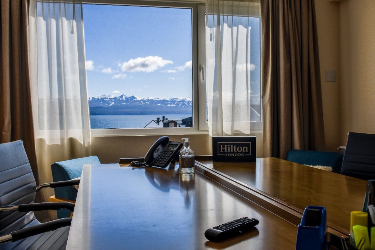 Una sala de conferencias con una gran mesa y sillas y una ventana con vista al mar.