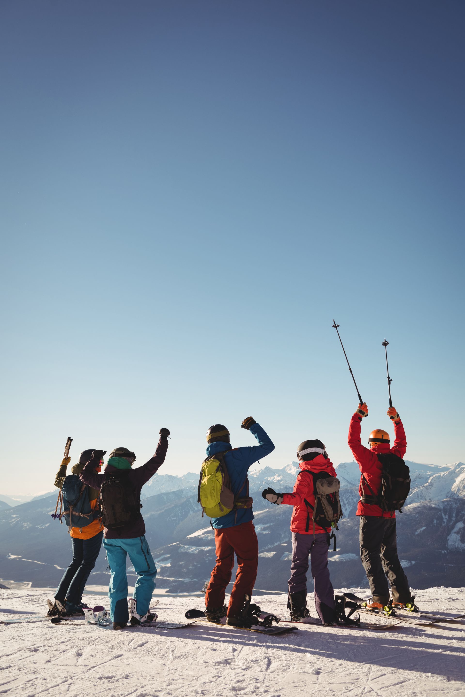 Un grupo de personas está de pie en la cima de una montaña cubierta de nieve.
