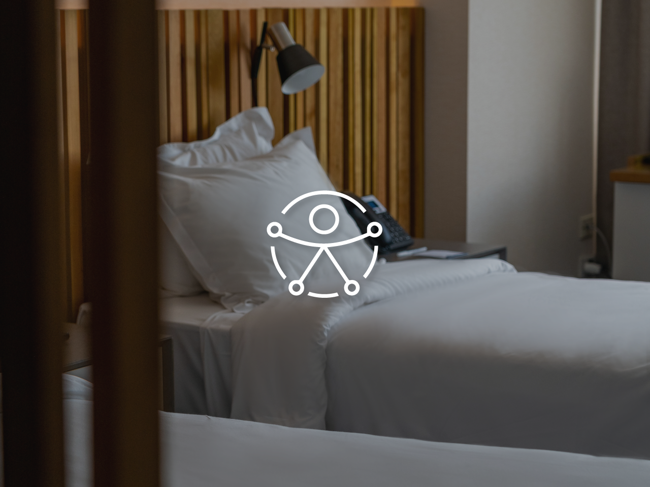Una cama con sábanas y almohadas blancas en una habitación de hotel.