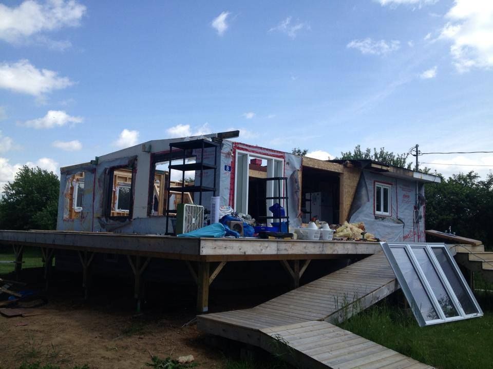 A house is being built on stilts in the middle of a field.