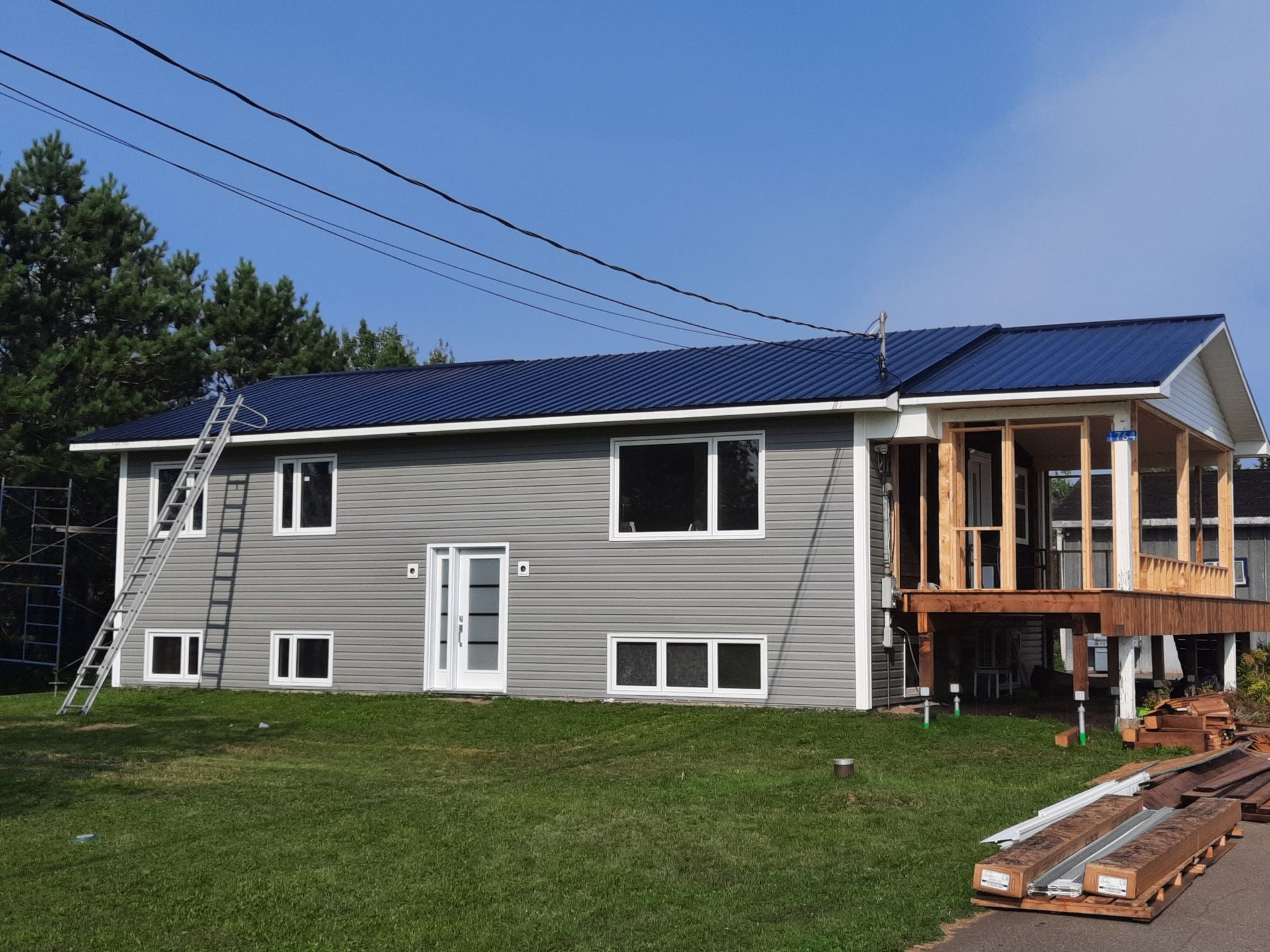 A house with a blue roof is under construction