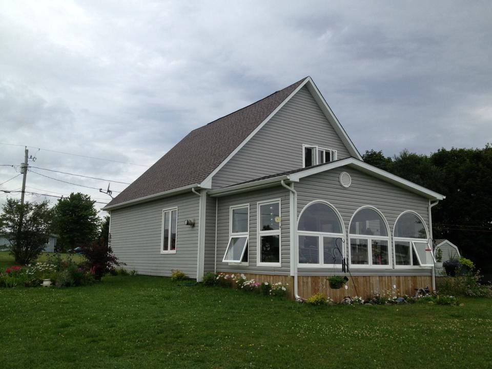 A house with a screened in porch and lots of windows