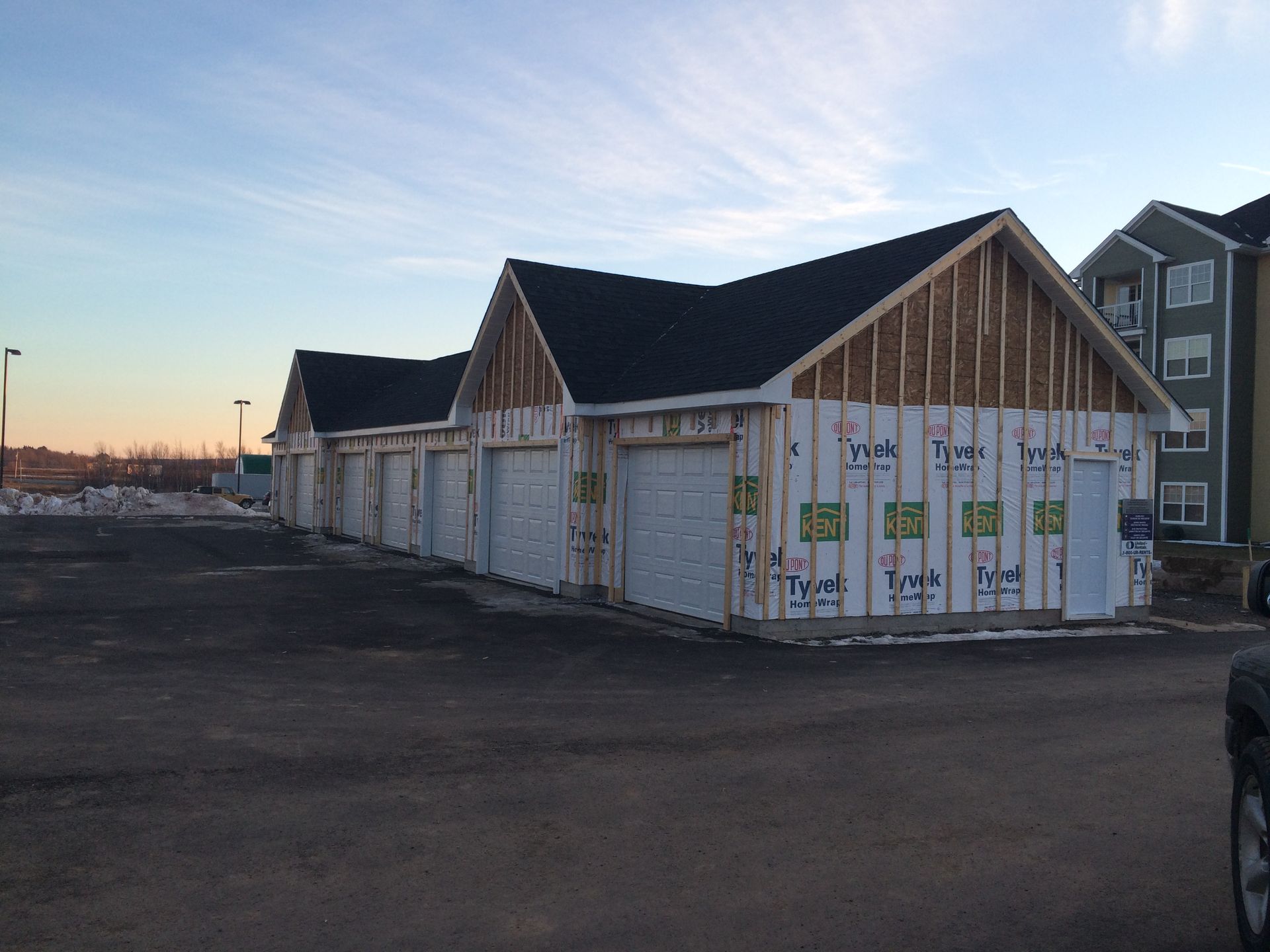 A car is parked in front of a building under construction