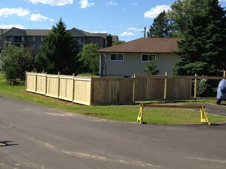 A wooden fence is being built in front of a house