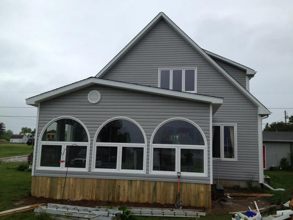 A house with a screened in porch and arched windows