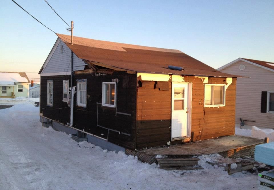 A small house with a red roof and a white door