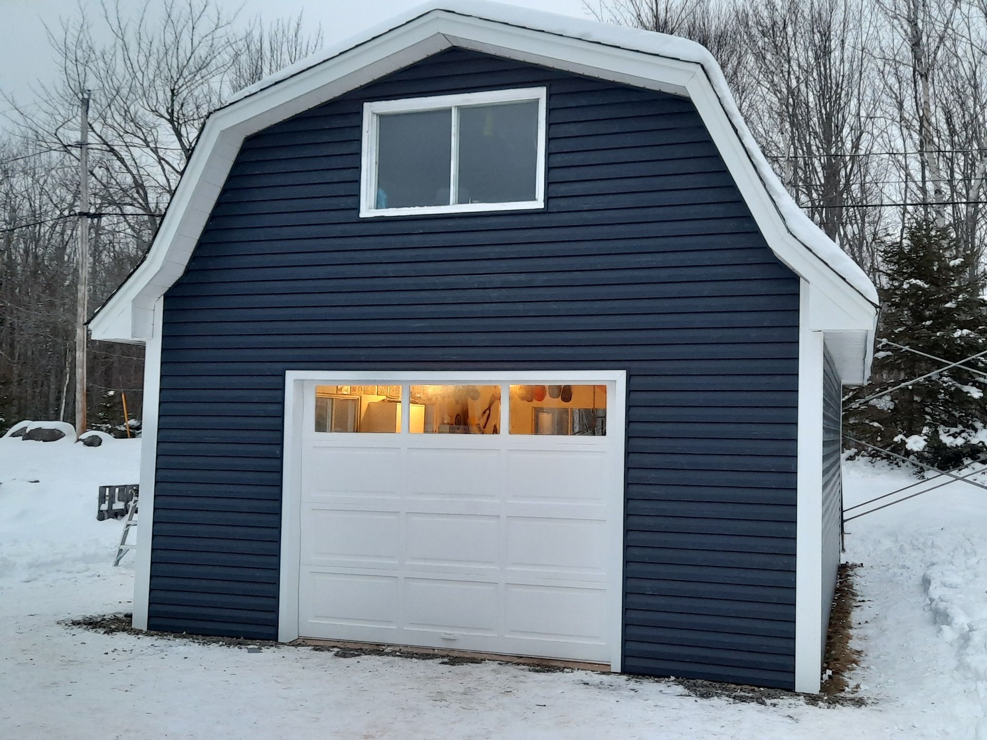 A blue garage with a white door and a window