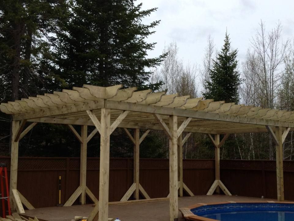 A wooden pergola is being built over a pool