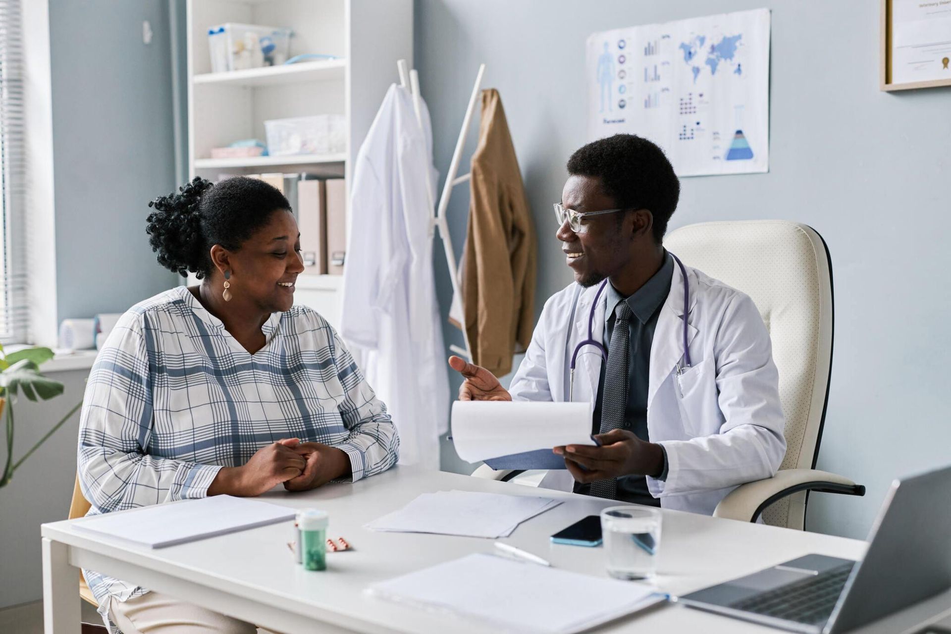 Doctor and patient reviewing paperwork at a desk in a medical office.