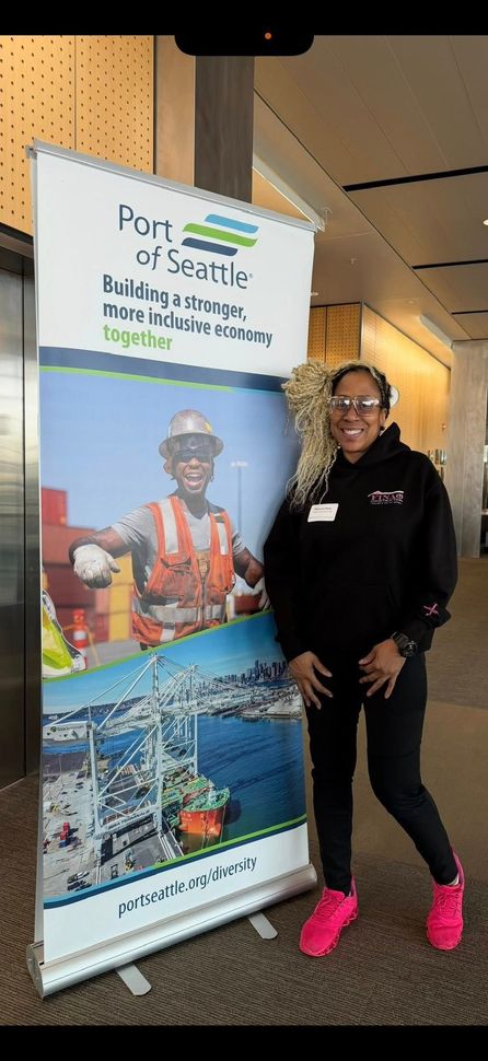 Construction workers in hard hats reviewing blueprints. They are smiling and appear to be discussing a project on-site.