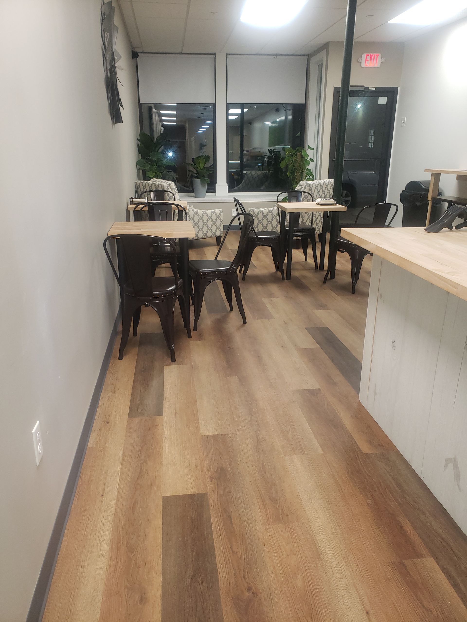 A long hallway with tables and chairs in a restaurant.