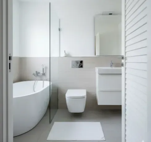 Modern white bathroom with bathtub, toilet, and vanity. Gray floor and neutral walls.