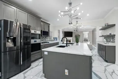 Modern gray kitchen with stainless steel appliances, marble countertops, and island.