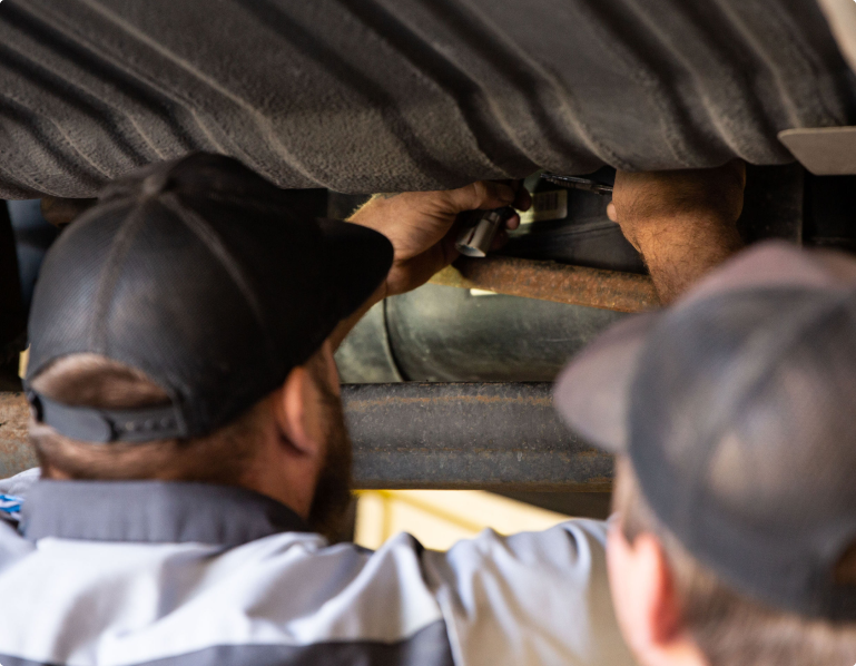 Technicians working underneath vehicle | Pat's Auto Repair & Towing