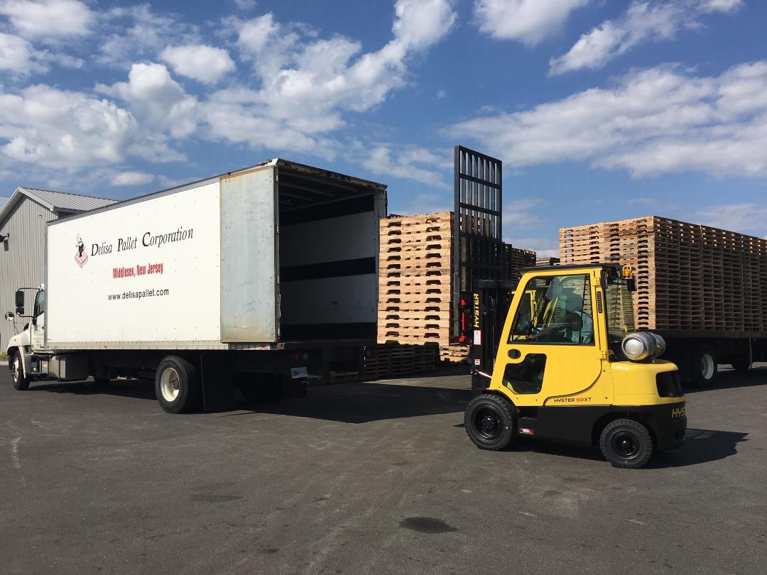 Forlift loading pallets onto a box truck for delivery