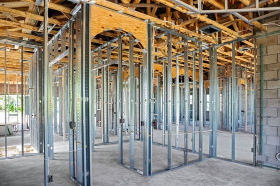 Building interior with metal frames and exposed wooden beams under construction. Building interior with metal frames and exposed wooden beams under construction.