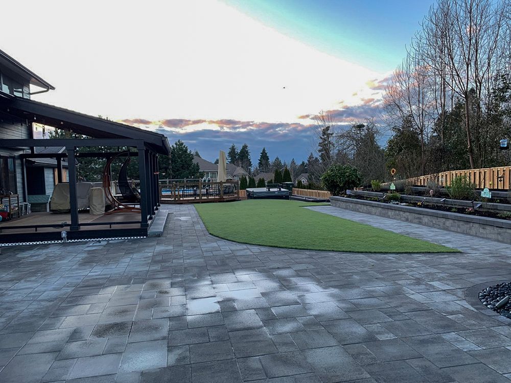 Patio with outdoor living area, green lawn, and mountain view on a cloudy day.