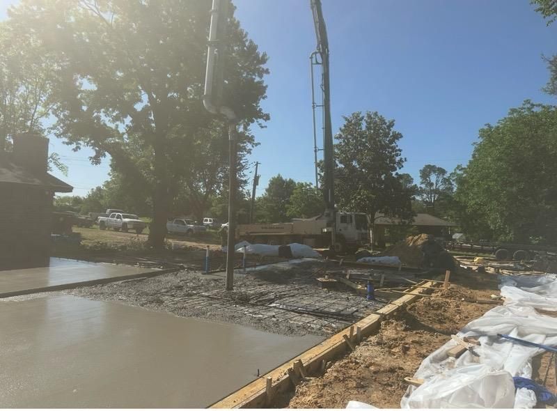 A man is pouring concrete into a wooden frame.