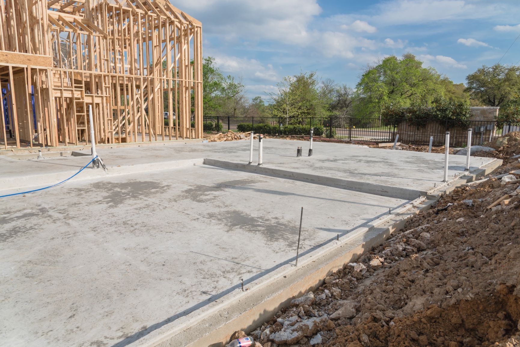 A man is pouring concrete into a wooden frame.
