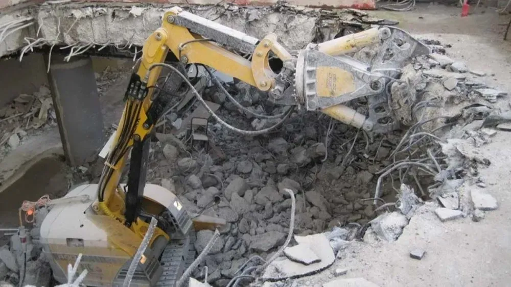 A man is pouring concrete into a wooden frame.