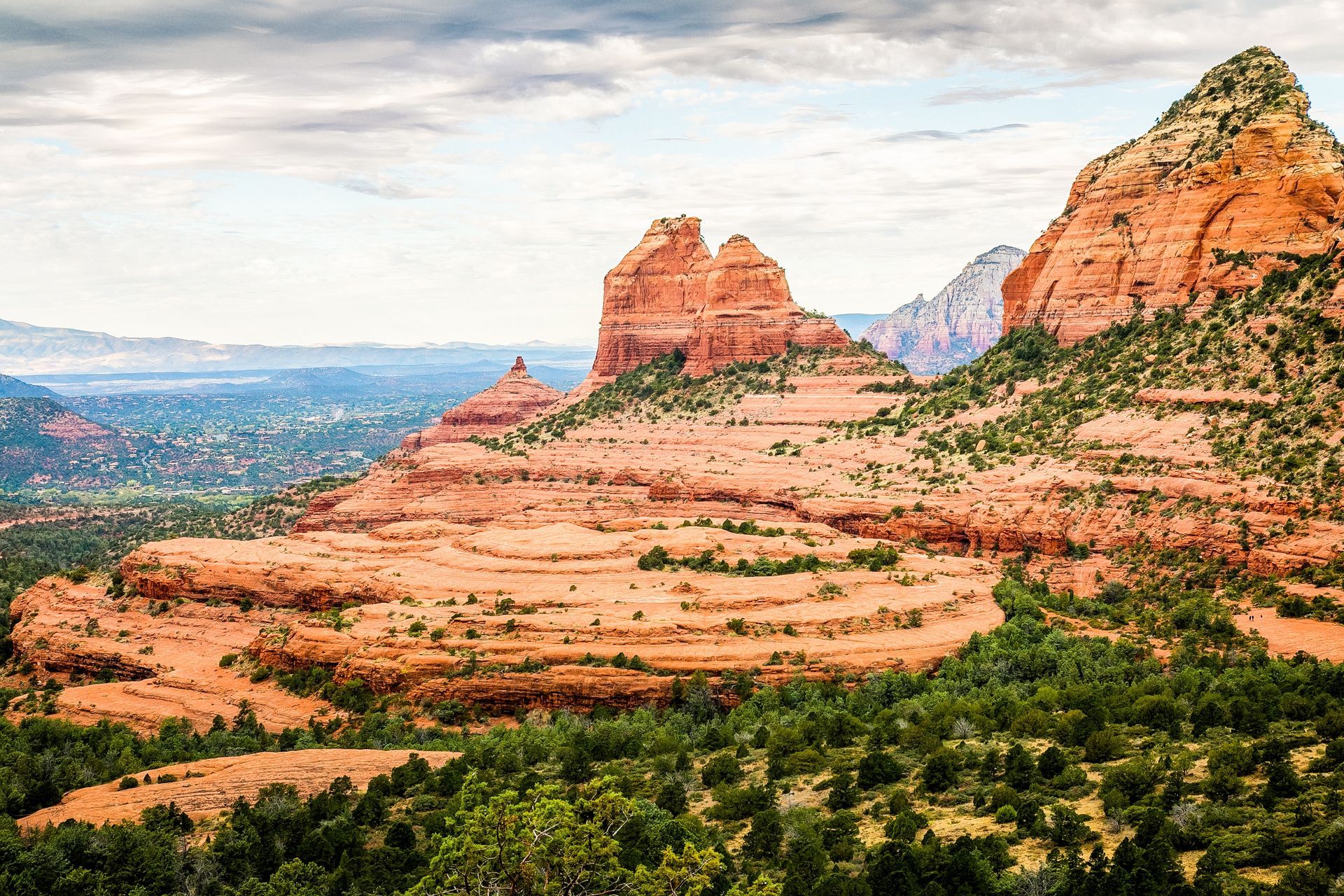 A view of a desert landscape with mountains and trees.