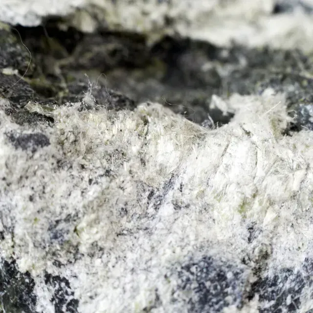 Verwijderen van asbesthoudend materiaal door gespecialiseerde vakmensen met naleving van strikte veiligheidsmaatregelen.