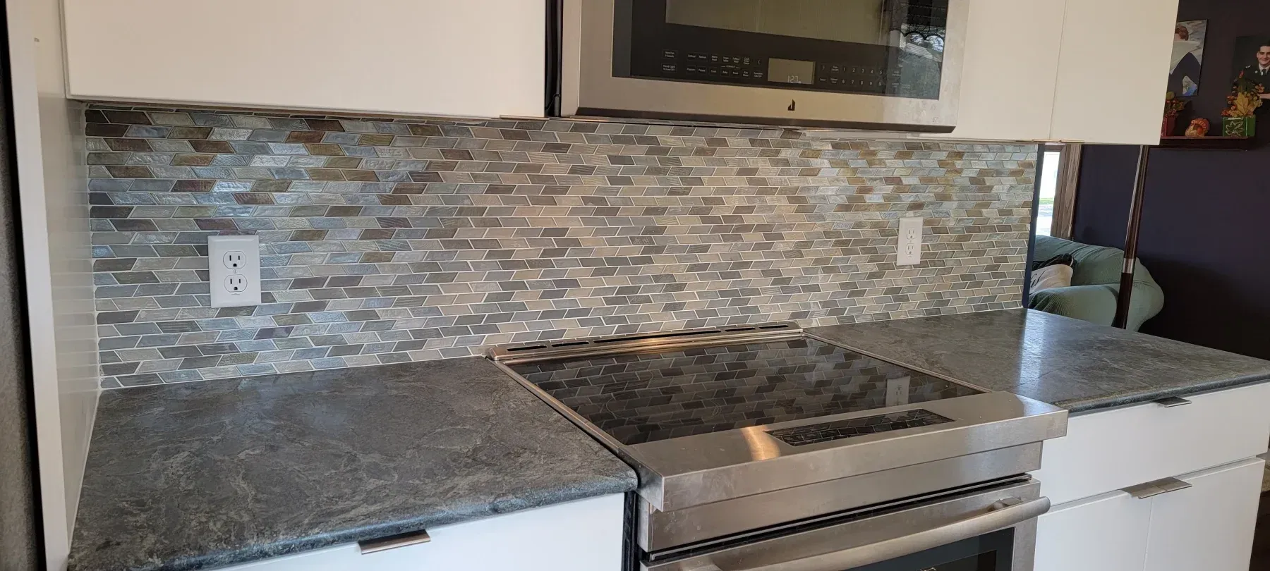 Kitchen with granite countertops, tiled backsplash, and stainless steel appliances.