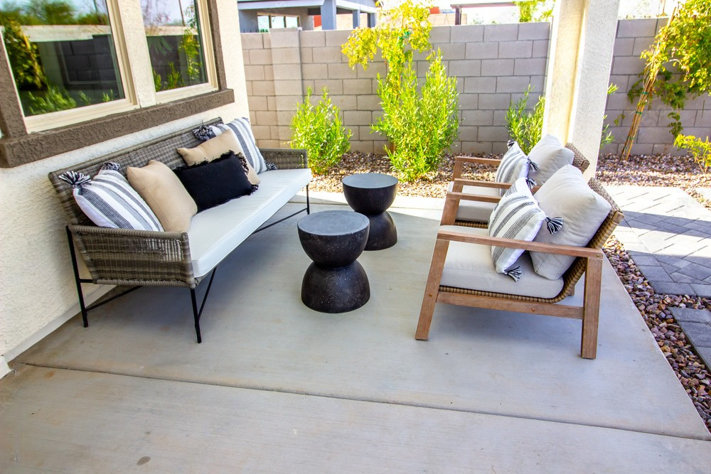 There is a patio with a couch and chairs on it.