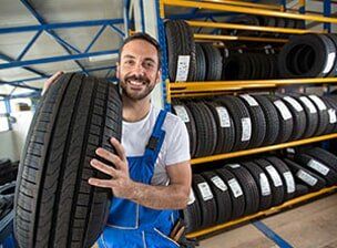 Mechanic Carrying Tire - Auto Repair in Glenmont NY