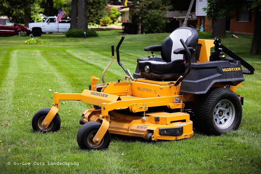 A Yellow And Black Lawn Mower Is Sitting On Top Of A Lush Green Lawn — Leslie Farm & Garden Machinery In South Grafton, NSW