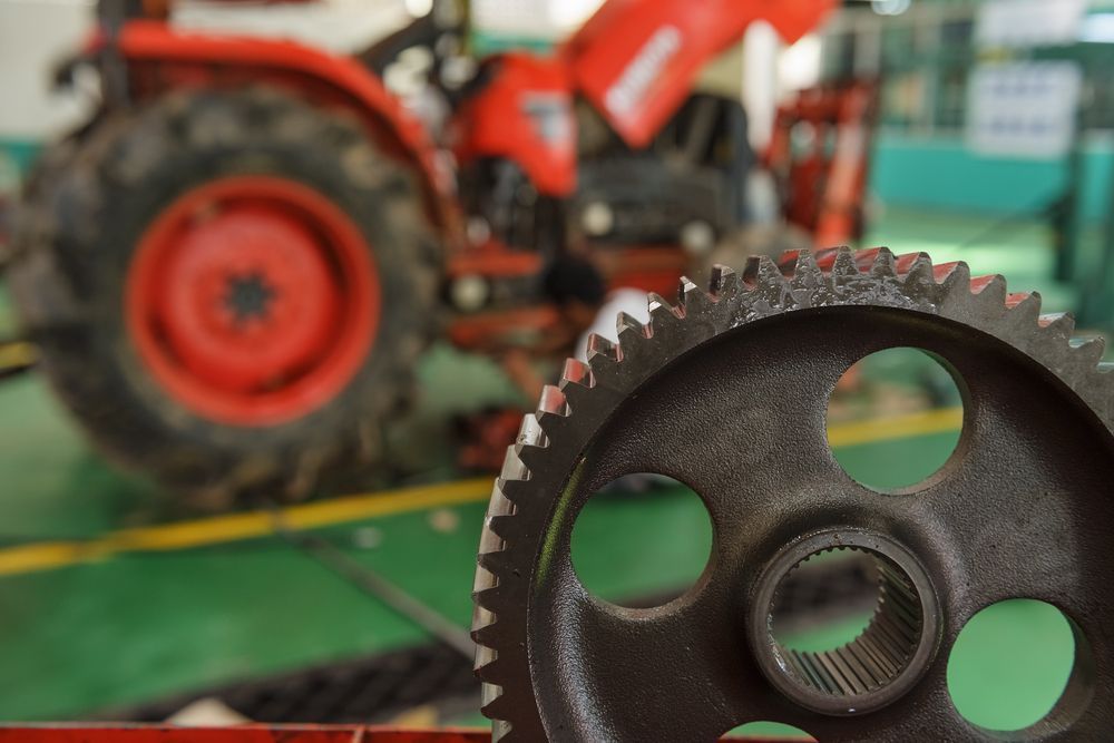 A Close Up Of A Gear With A Tractor In The Background — Leslie Farm & Garden Machinery In South Grafton, NSW