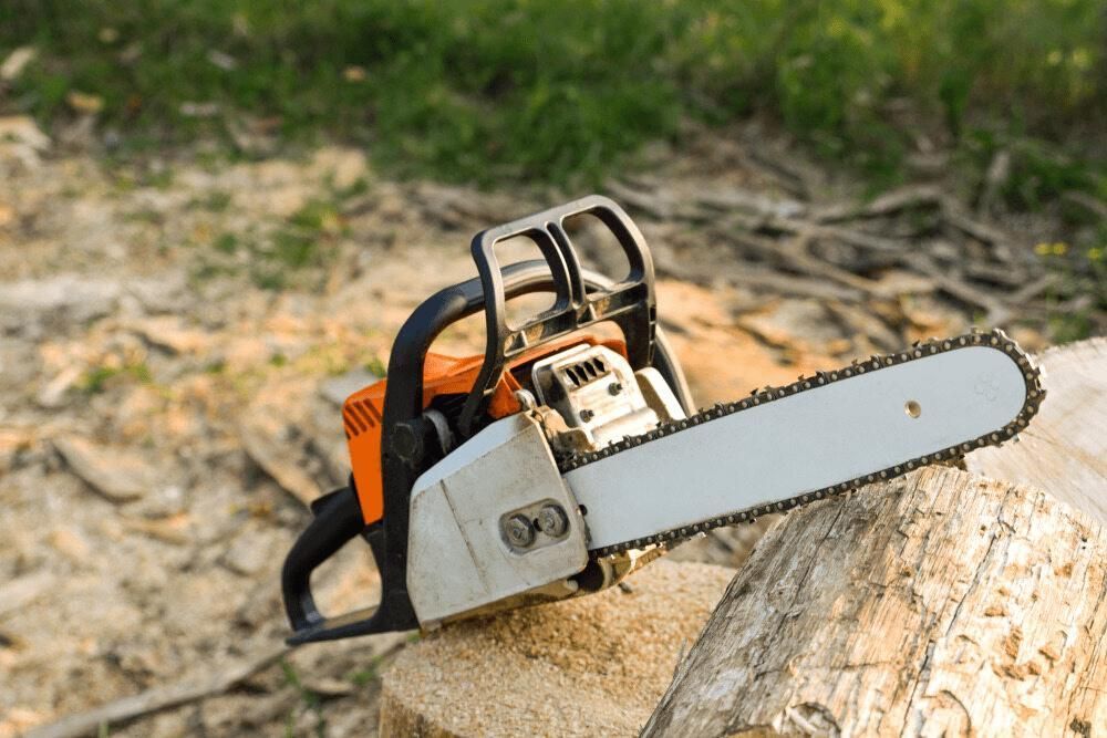 A Chainsaw Is Sitting On Top Of A Piece Of Wood — Leslie Farm & Garden Machinery In South Grafton, NSW