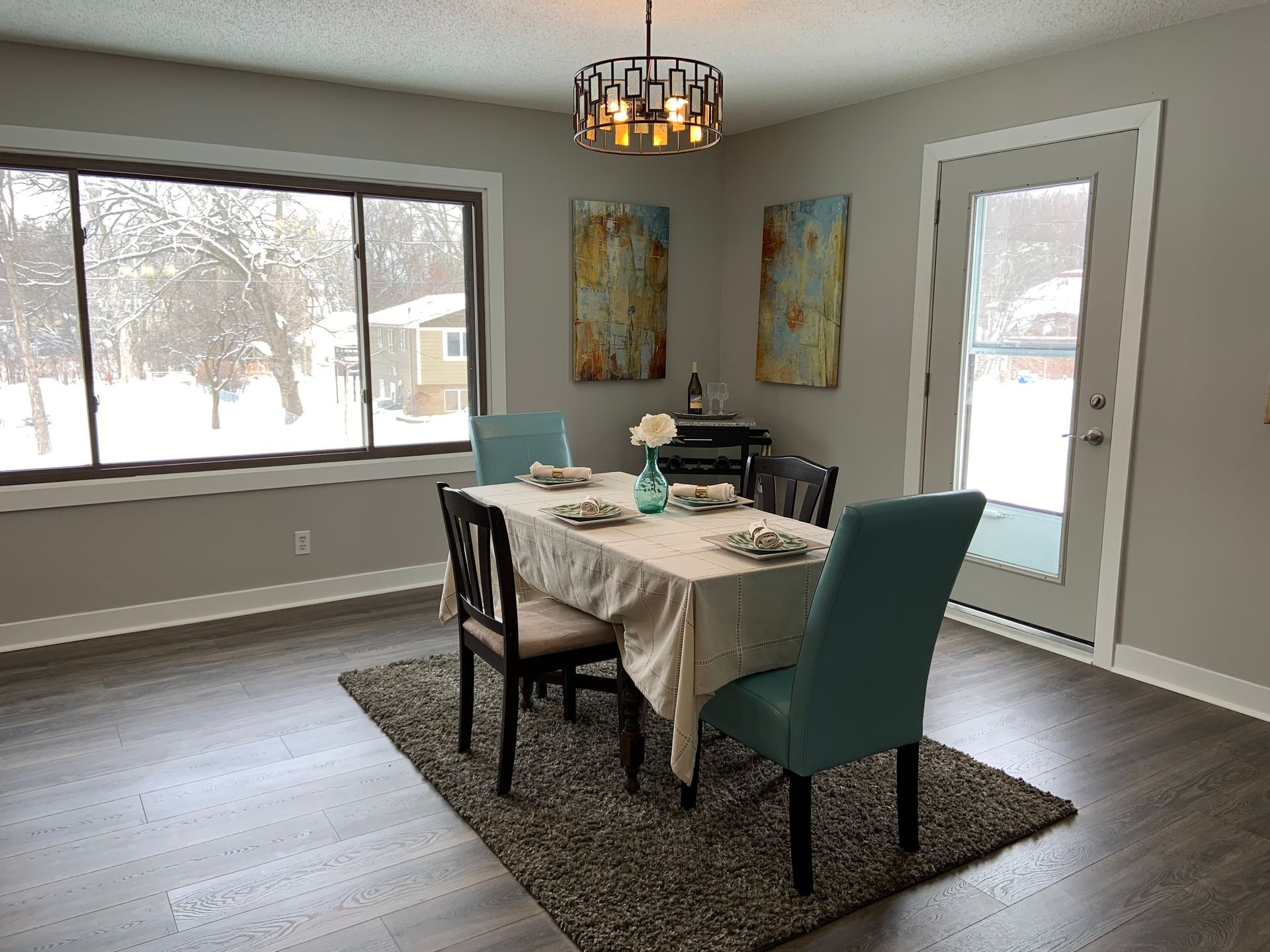 A dining room with a table and chairs and a chandelier.