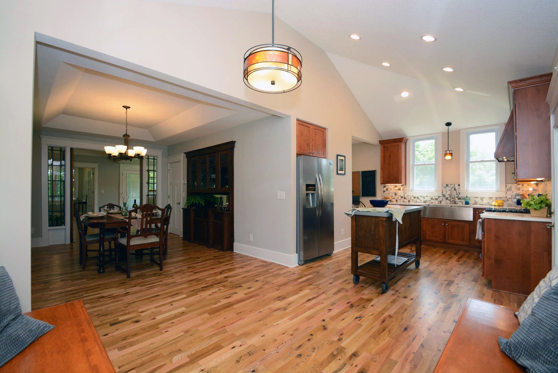 A kitchen and dining room in a house with hardwood floors.