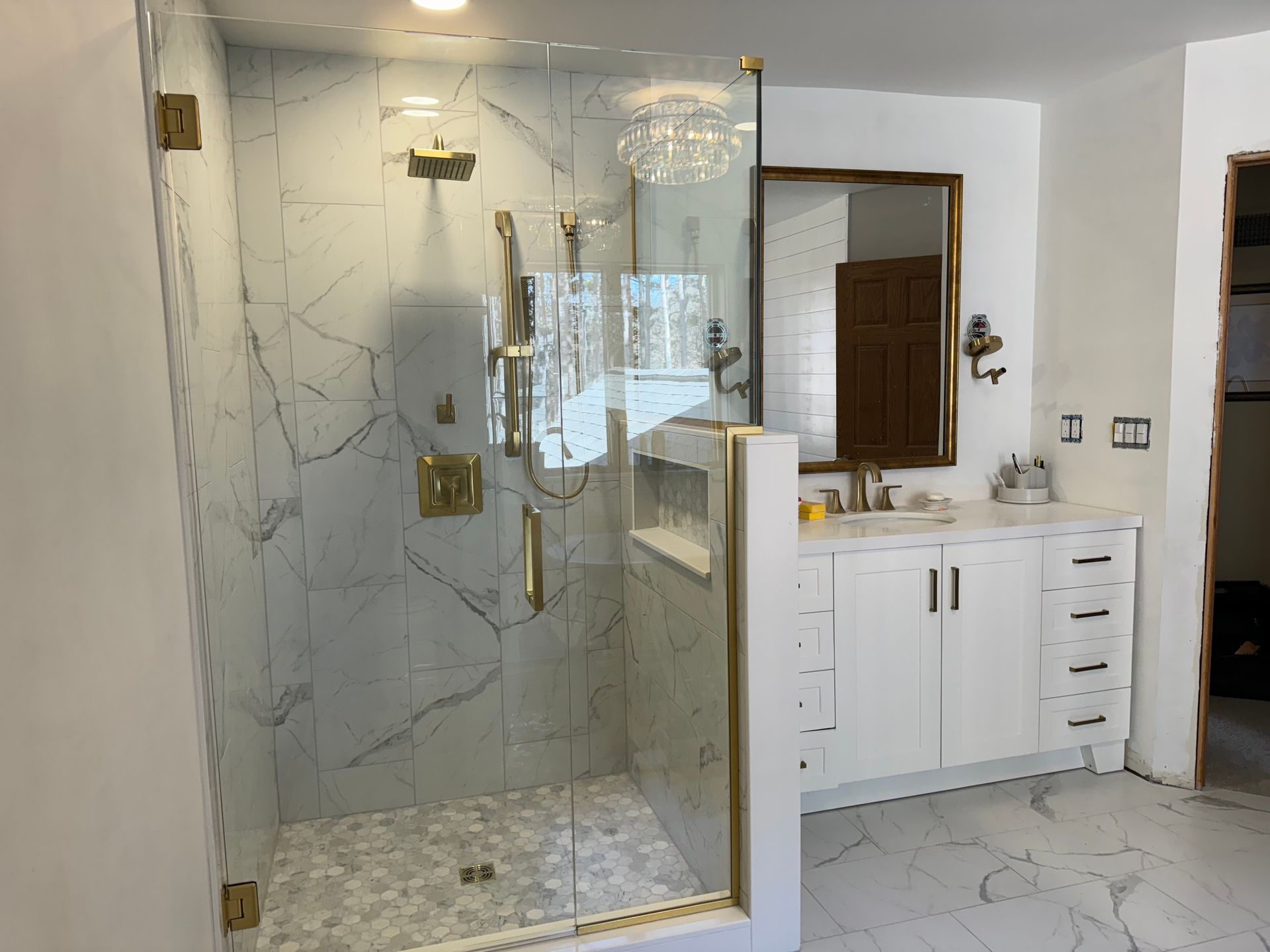 A bathroom with a walk in shower and a sink.