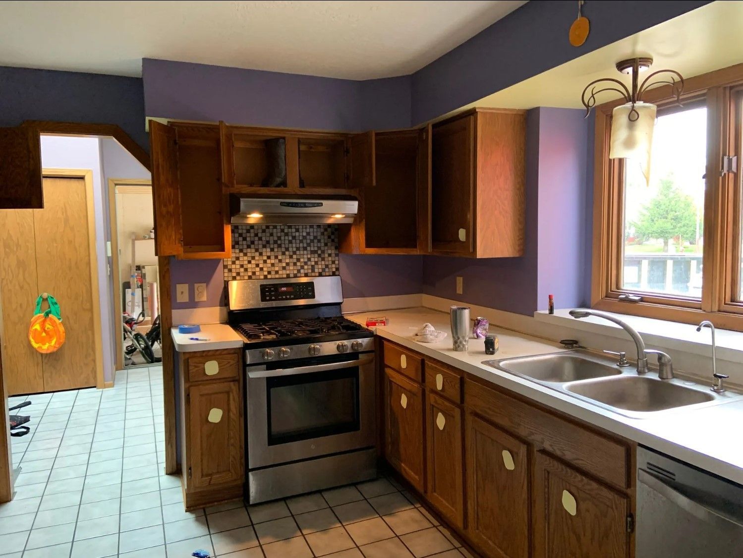 Kitchen with wood cabinets, stainless steel appliances, and purple walls.
