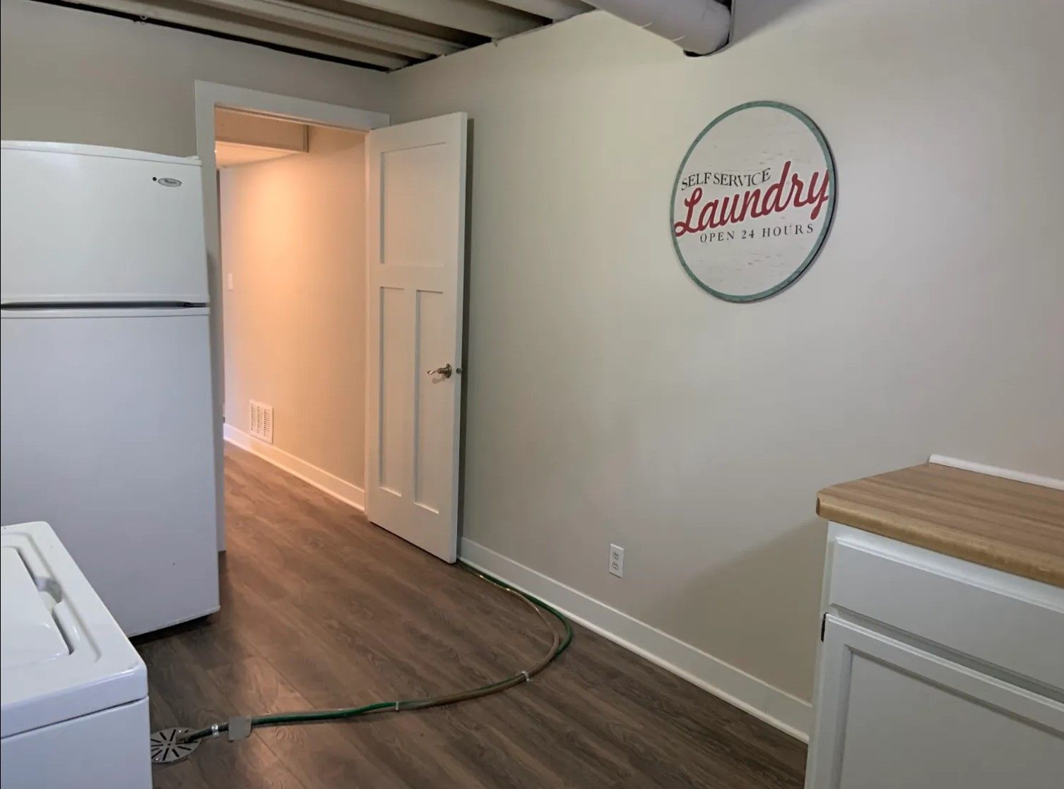 Laundry room with white appliances, wooden cabinets, and a